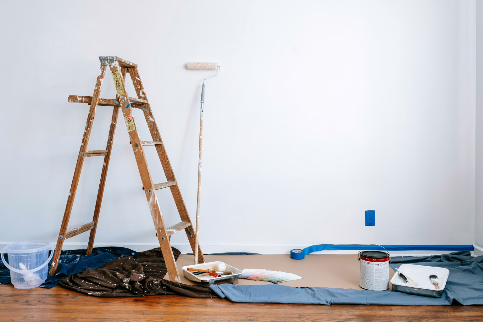 Ladder, floor covers and pot of paint as illustration for Harmony Home Organizing's handyman services