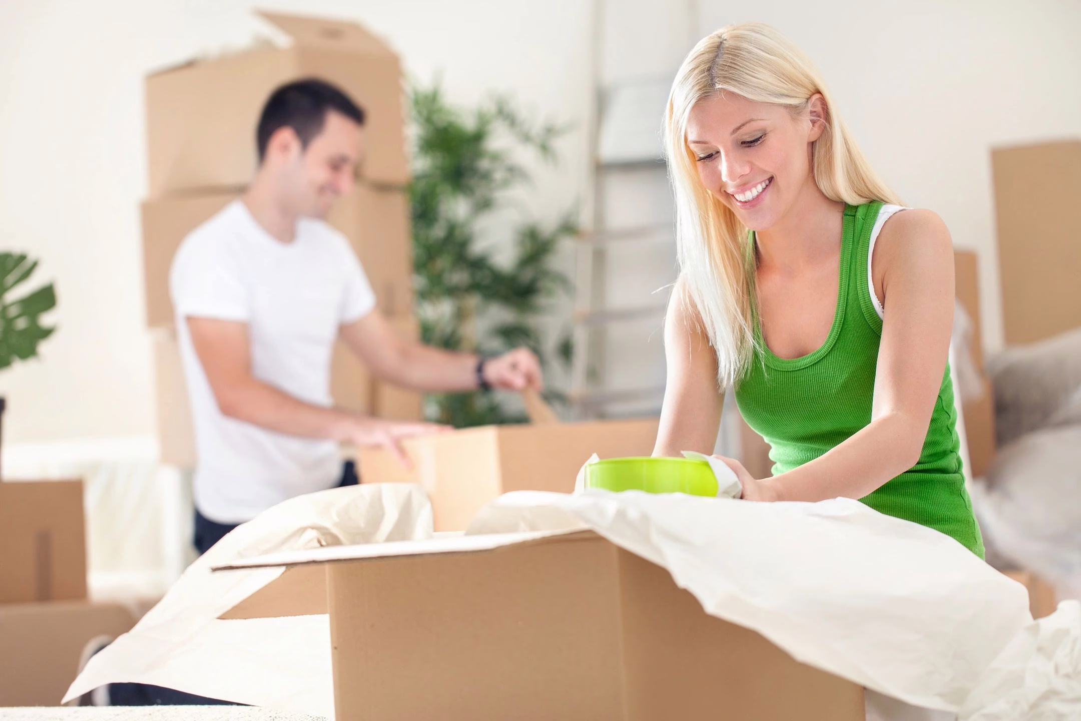 Woman and man packing boxes as illustration for Harmony Home Organizing's packing and unpacking services