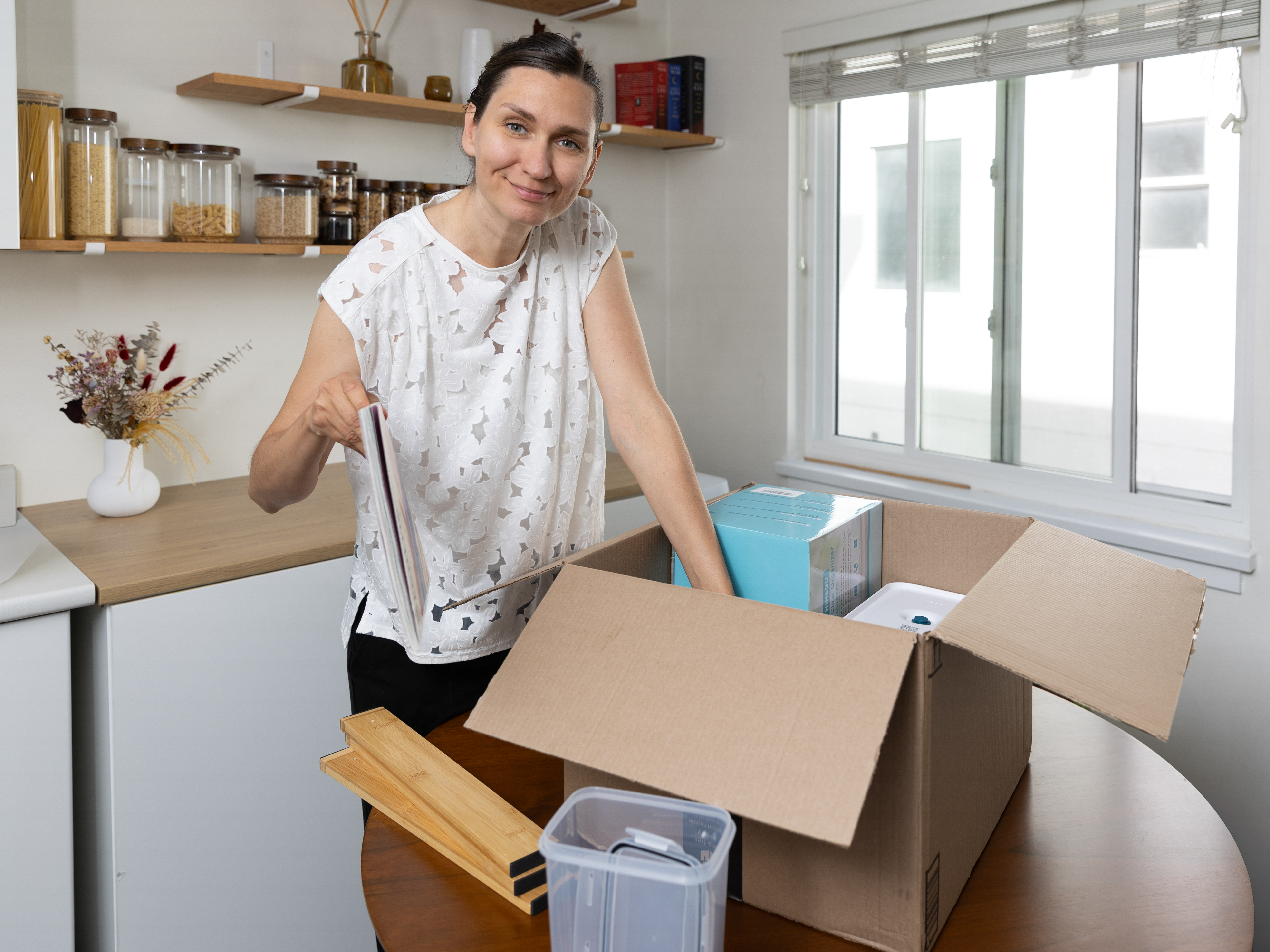 Professional Organizer in Victoria and Vancouver, Olena from Harmony Home Organizing, smiling while packing a moving box